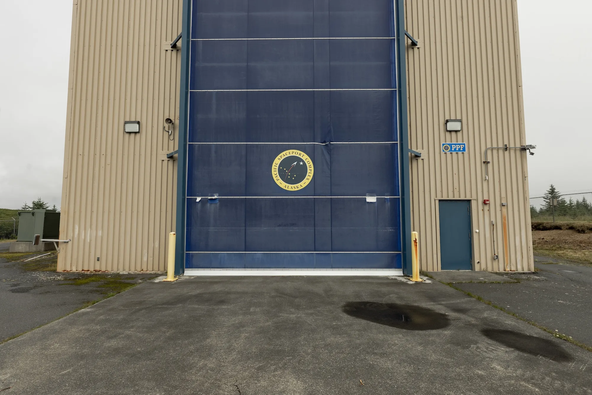 A large blue door with spaceport seal outside a building