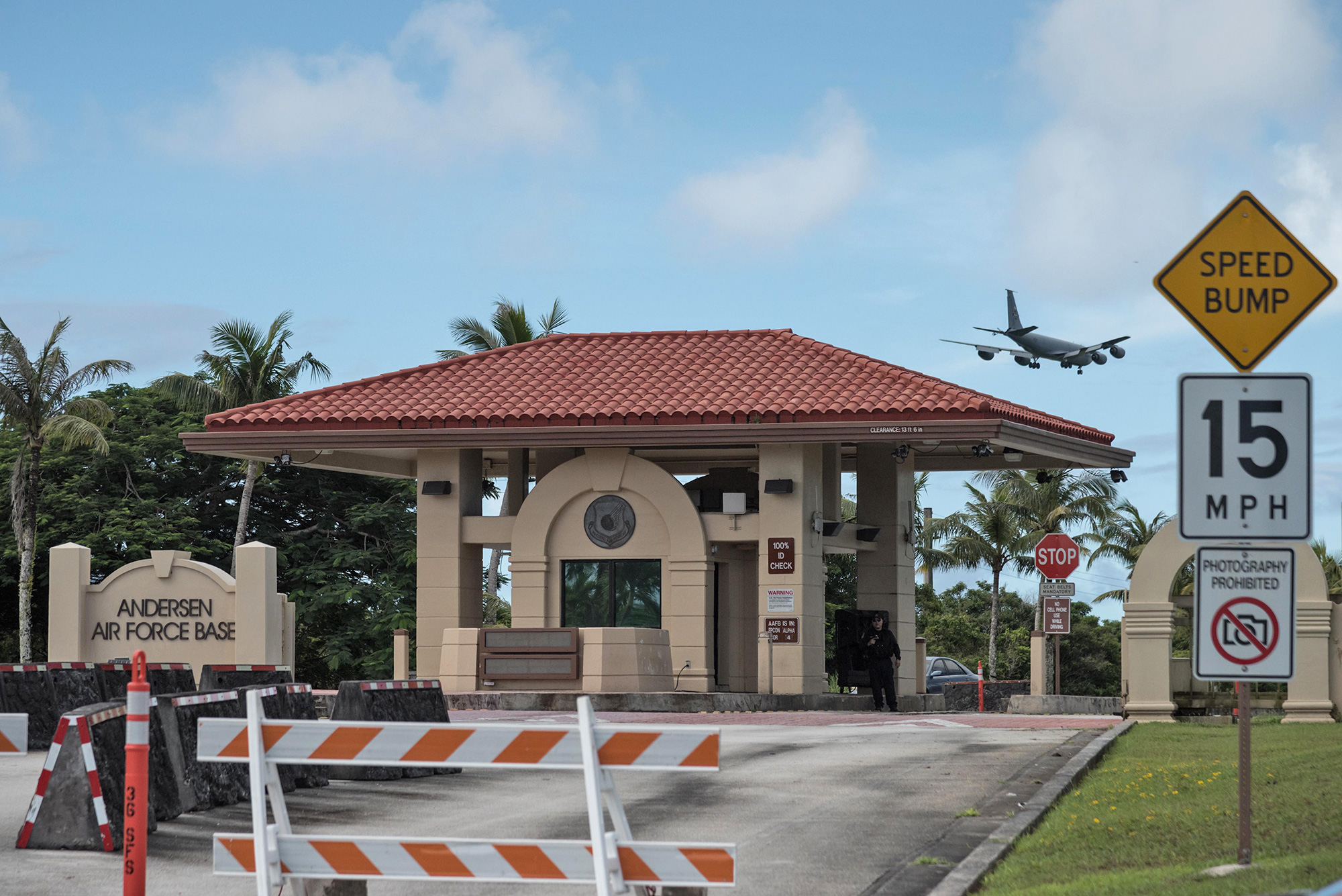 A large building with a gate on Guam with airplane in the backgrou d