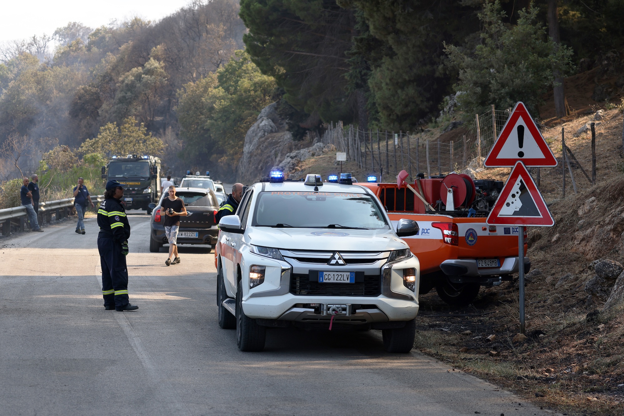firefighters and trucks block a road in sicily