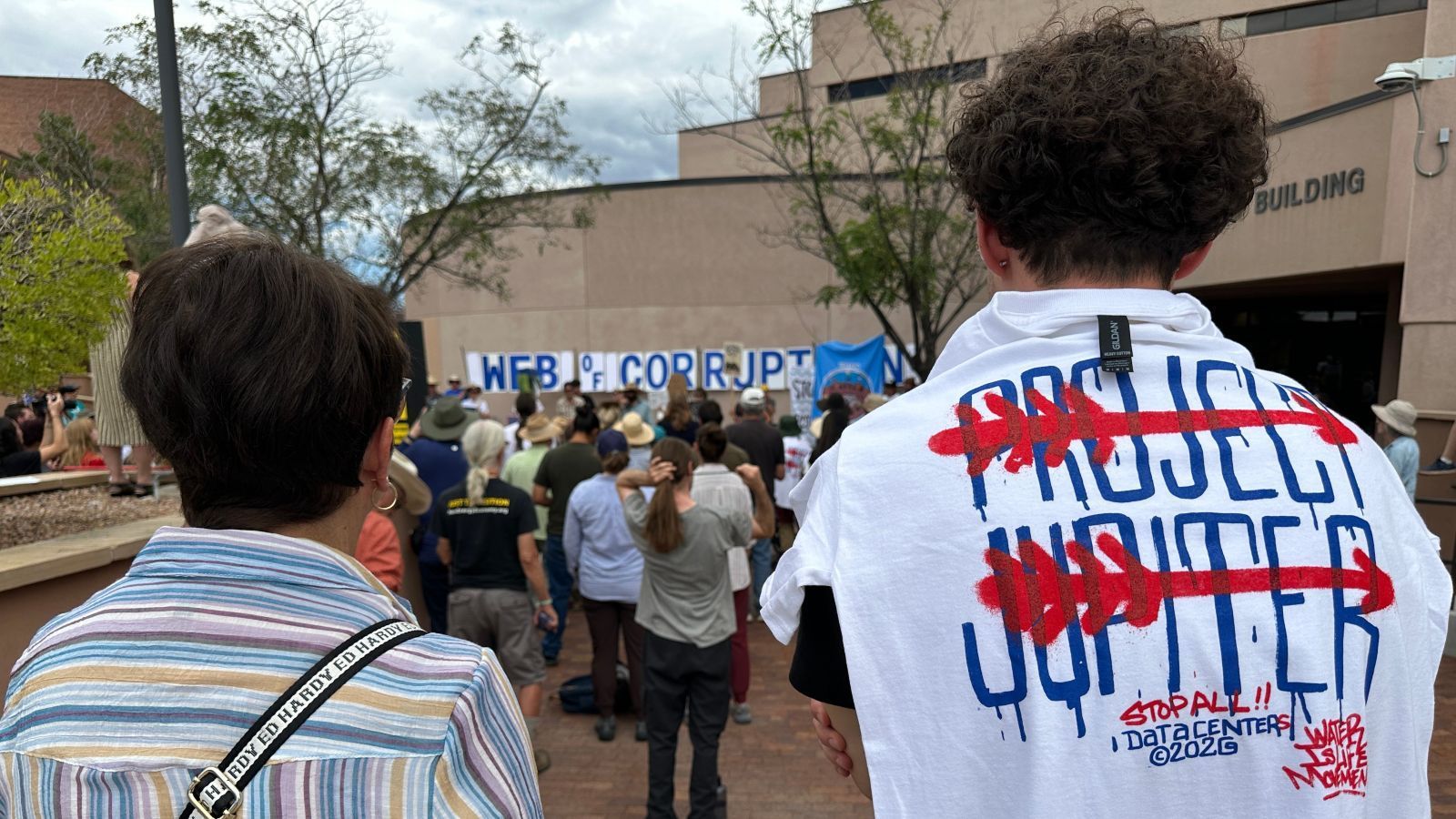A protestor wears a tee shirt with arrows running through the words Project Jupiter