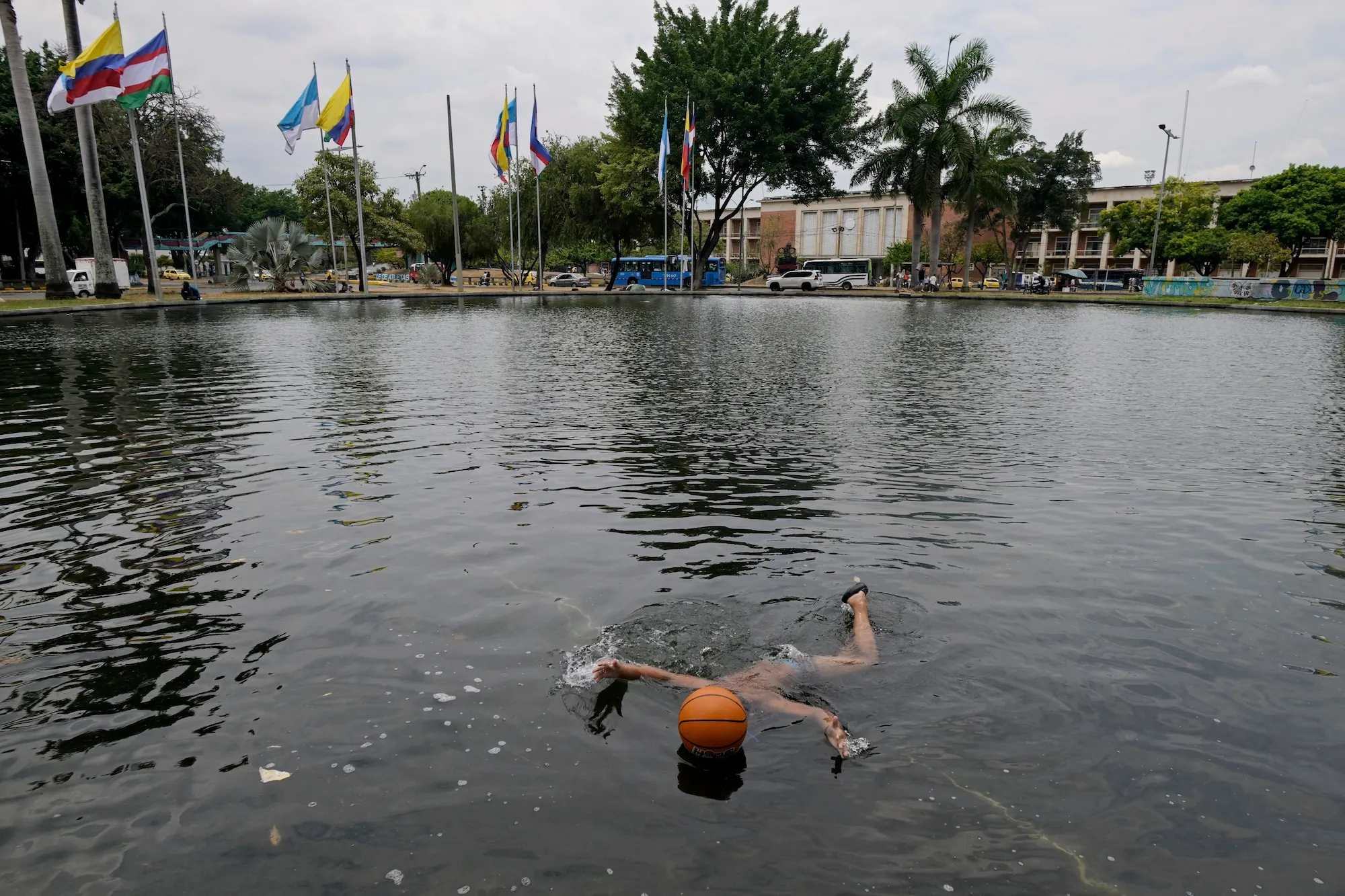 A person cools down in a lake next to a basketball
