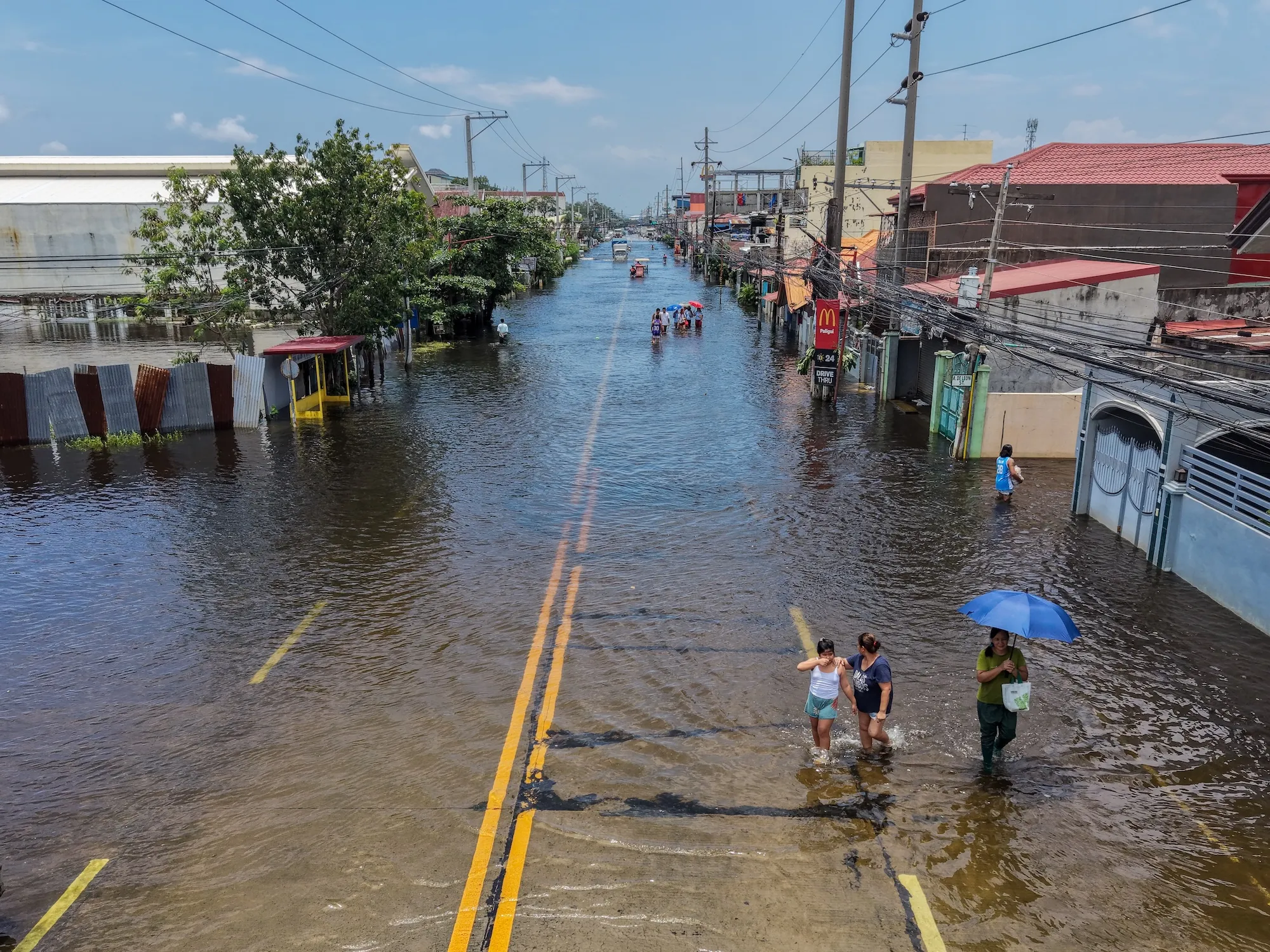 a flooded road with people in the Philippines