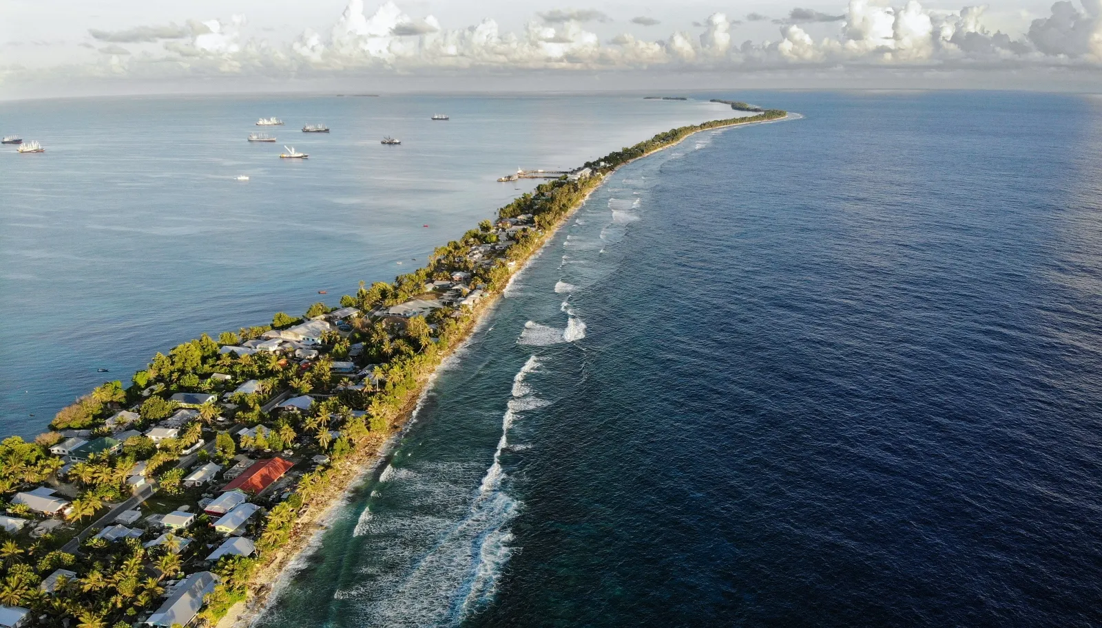 An aerial view of a strip of land between the Pacific Ocean and a lagoon in Funafuti, Tuvalu. The island nation of around 11,000 people is facing total inundation as sea levels rise.
