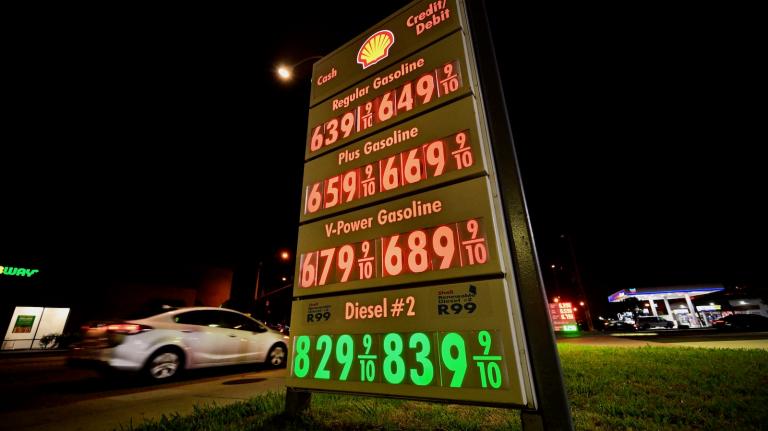 A motorist pulls into a gas station where the marque lists gas prices that include diesel fuel for eight dollars and twenty-nine cents a gallon.