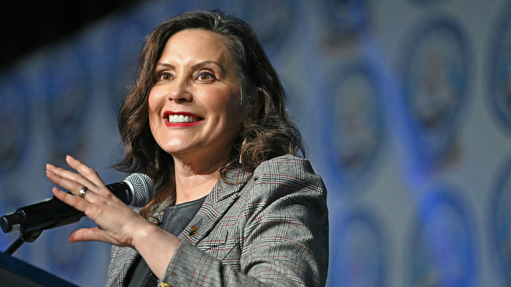 Close-up of Governor Gretchen Whitmer addressing a crowd from a lectern