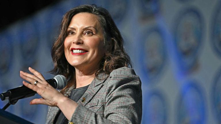 Close-up of Governor Gretchen Whitmer addressing a crowd from a lectern