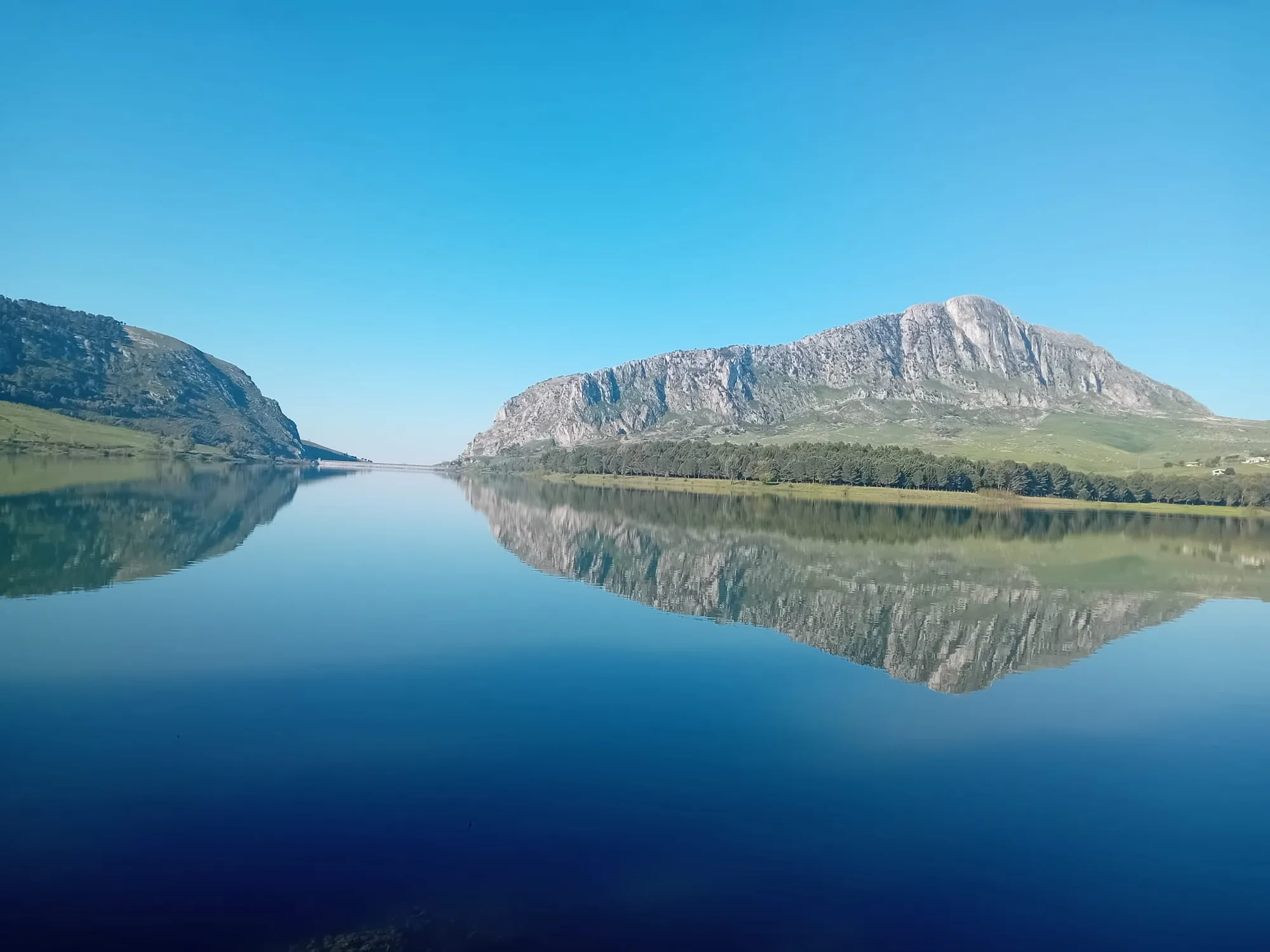 A large reflective lake near two mountains