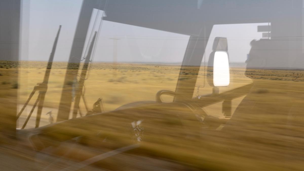 A rural field is visible out the window of a bus