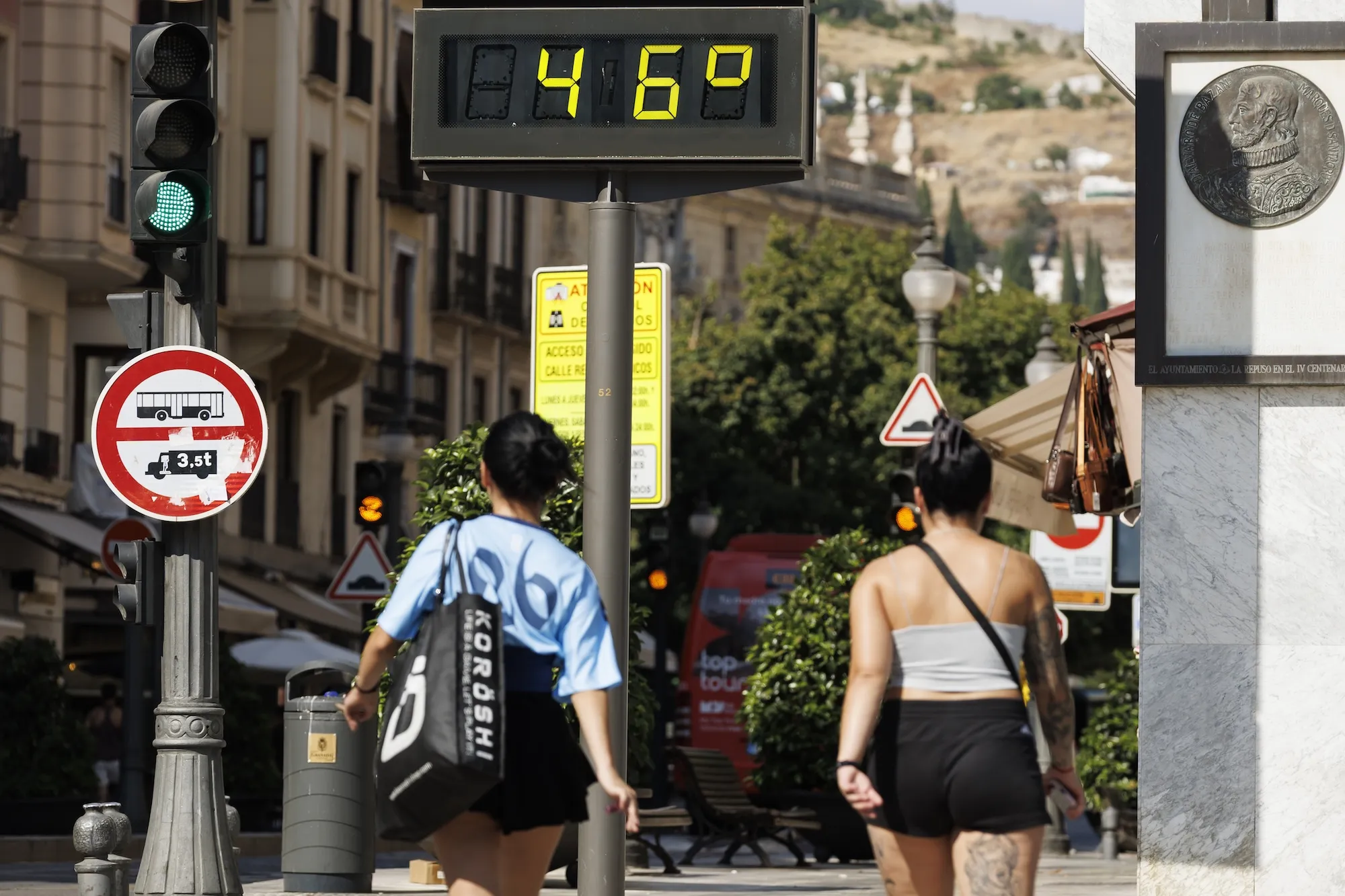 A digital temperature reading says '46' degrees on a city street
