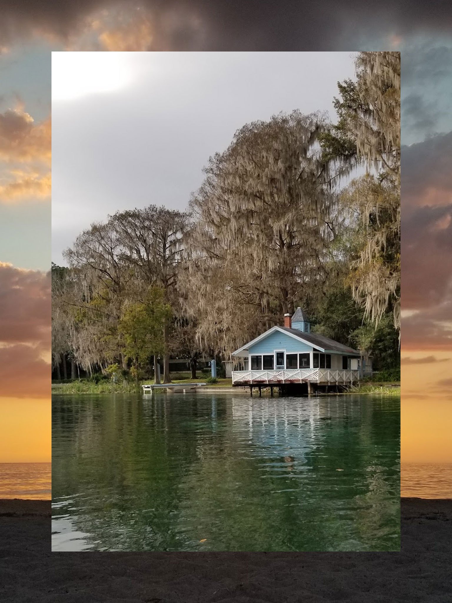 A collage consisting of two vertical photos, the outside functioning a border and the inside fully visible. The outside photo is a beach at sunset. The inner photo is a house on stilts near a lake with Spanish moss growing overhead.