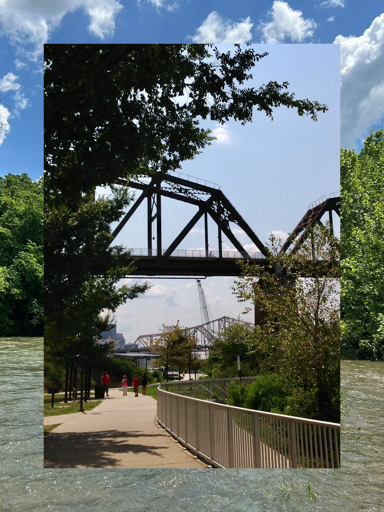 A collage consisting of two vertical photos, the outside functioning a border and the inside fully visible. The outside photo is a lake or river with trees and blue sky. The inner photo is a riverfront with bridge on a sunny day.