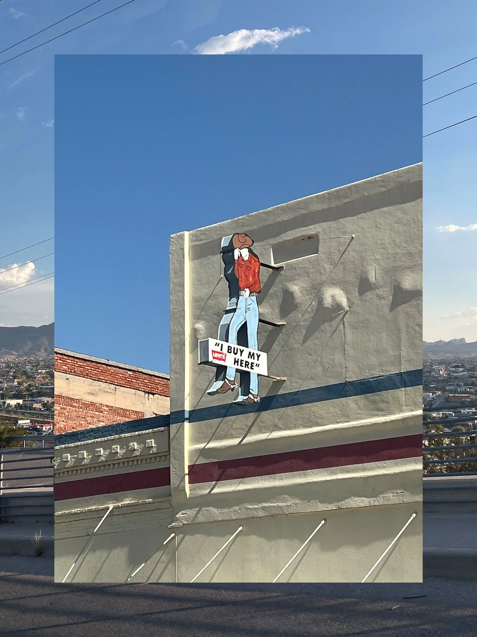 A collage consisting of two vertical photos, the outside functioning a border and the inside fully visible. The outside photo is a sunny view of El Paso. The inner photo is of a storefront sign that says 'I buy my Levis here' with an image of a cowboy.