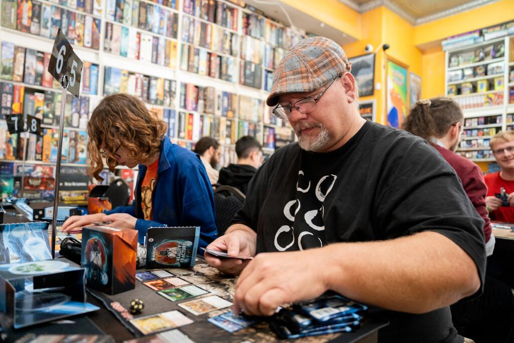 Man seated looking through trading cards
