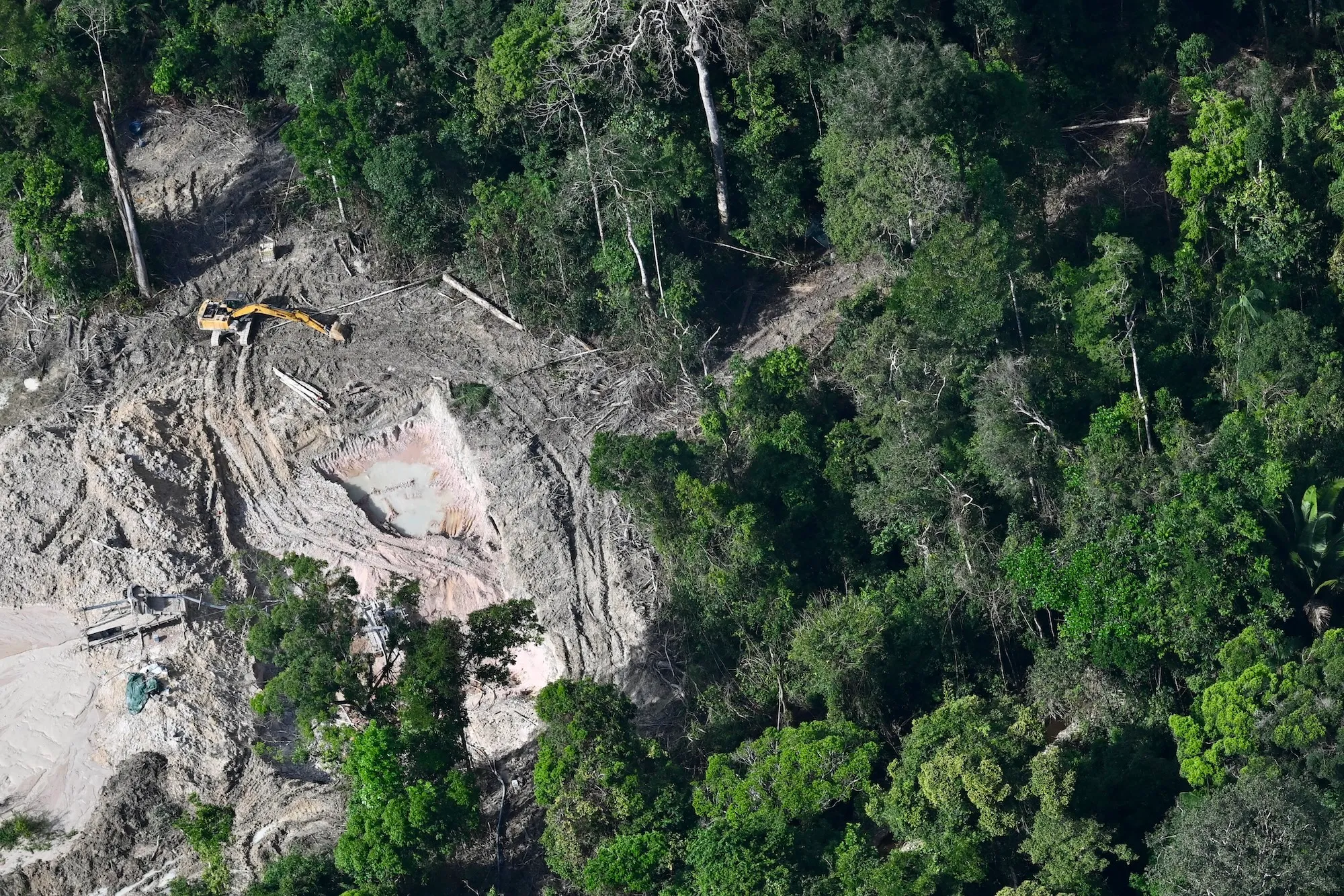 A backhoe near a cleared part of the Amazon rainforest