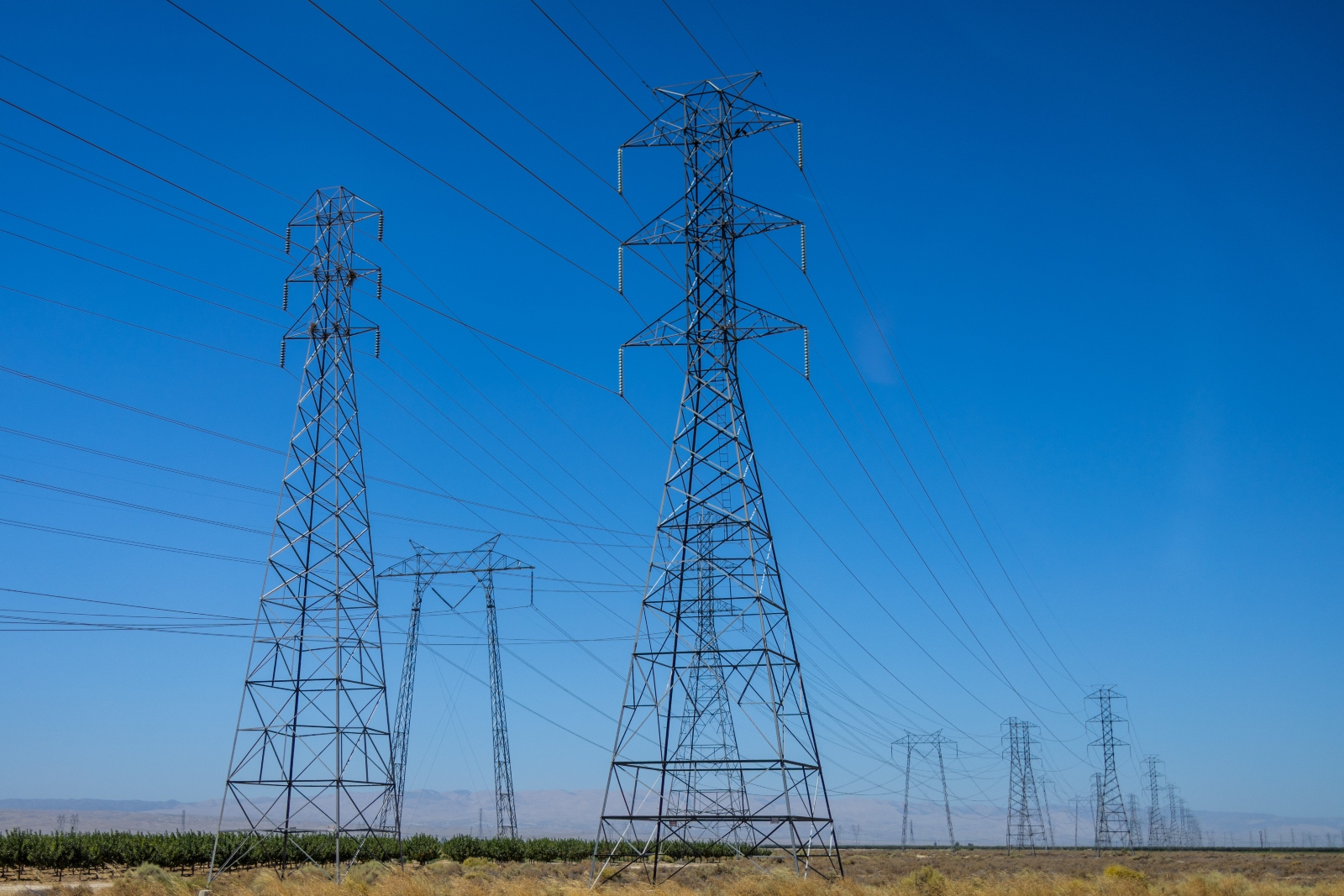 High-voltage transmission lines run through the Central Valley of California. The bipartisan permitting bill would overhaul federal rules for transmission, requiring utilities to plan for more lines that move clean energy around the country.