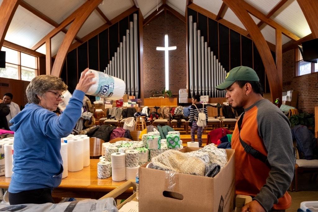 People hand out supplies in a church